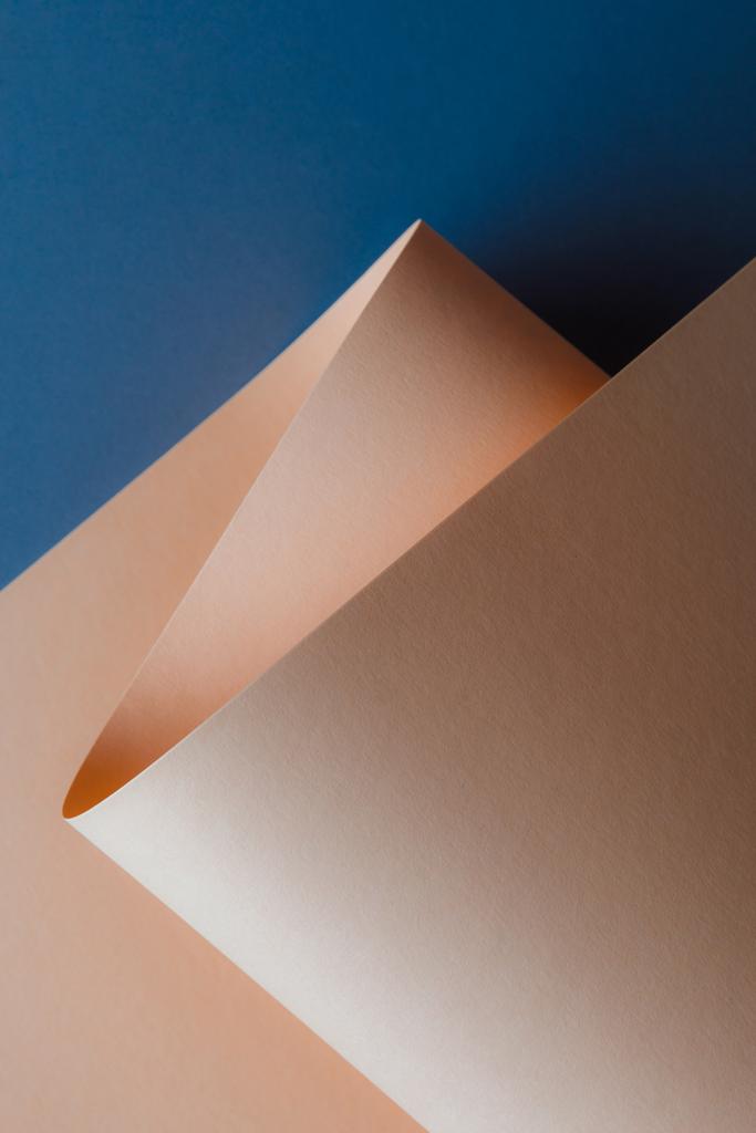 close-up view of beautiful tender beige paper sheet on dark blue background - Photo, Image