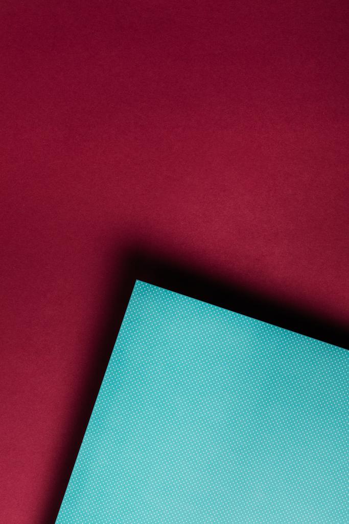 creative turquoise paper sheet on grungy maroon background - Photo, Image