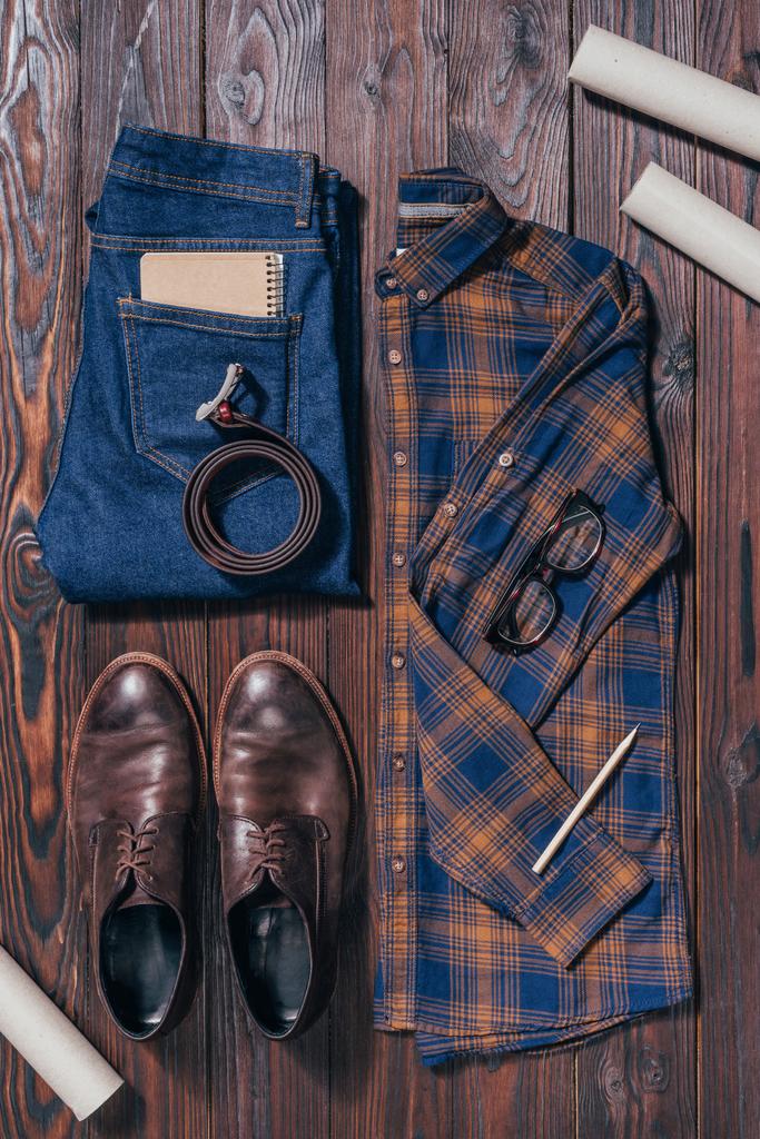 Układ płaski z Męska koszula, buty, dżinsy, okulary i plany architektury rozmieszczone na powierzchni drewnianych - Zdjęcie, obraz