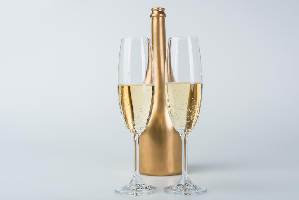bottiglia d'oro di champagne e bicchieri trasparenti su superficie bianca
 - Foto, immagini