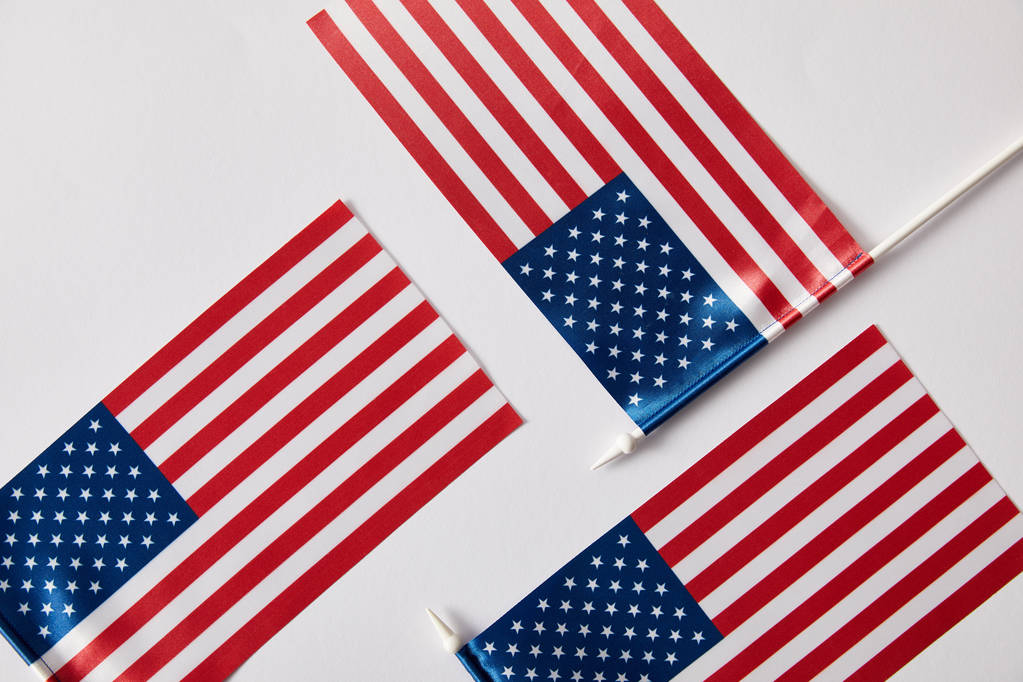 Κάτοψη των κονταριών σημαίας των Ηνωμένων Πολιτειών της Αμερικής σχετικά με λευκή επιφάνεια  - Φωτογραφία, εικόνα