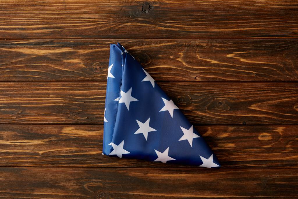 verhoogde weergave van gevouwen Verenigde Staten vlag op houten oppervlak - Foto, afbeelding