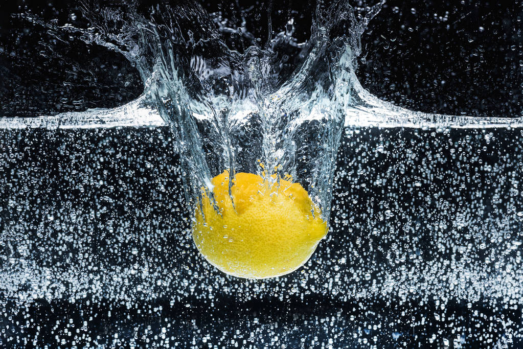 close up view of lemon in water isolated on black - Photo, Image