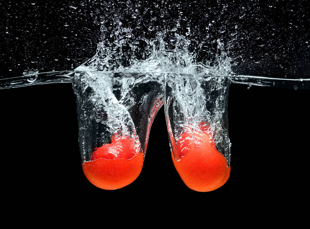 close up view of ripe tomatoes falling into water isolated on black - Photo, Image