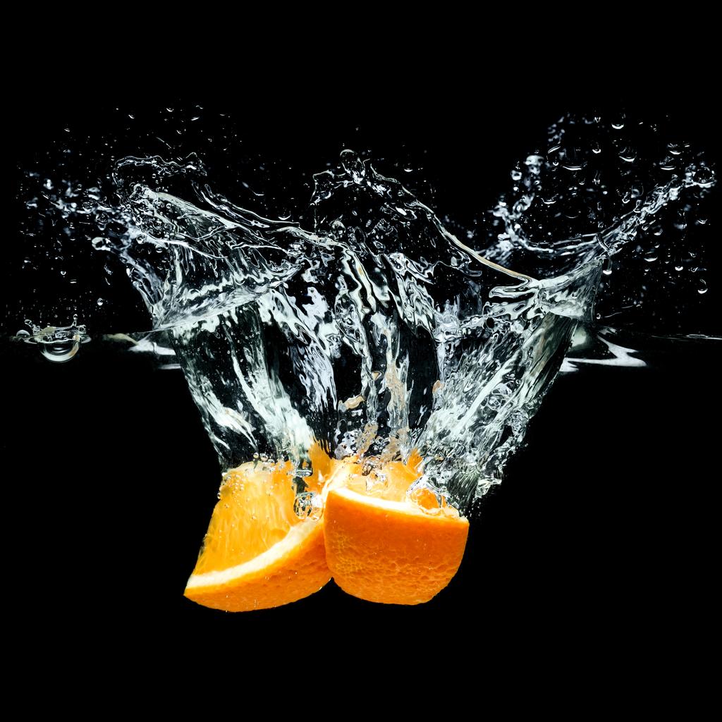 vue rapprochée de morceaux d'agrumes orange dans de l'eau isolée sur noir
 - Photo, image