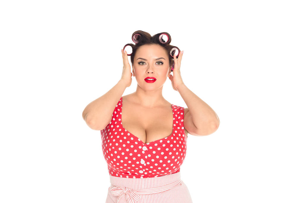 attractive plus size woman with curlers in hair looking at camera isolated on white - Photo, Image