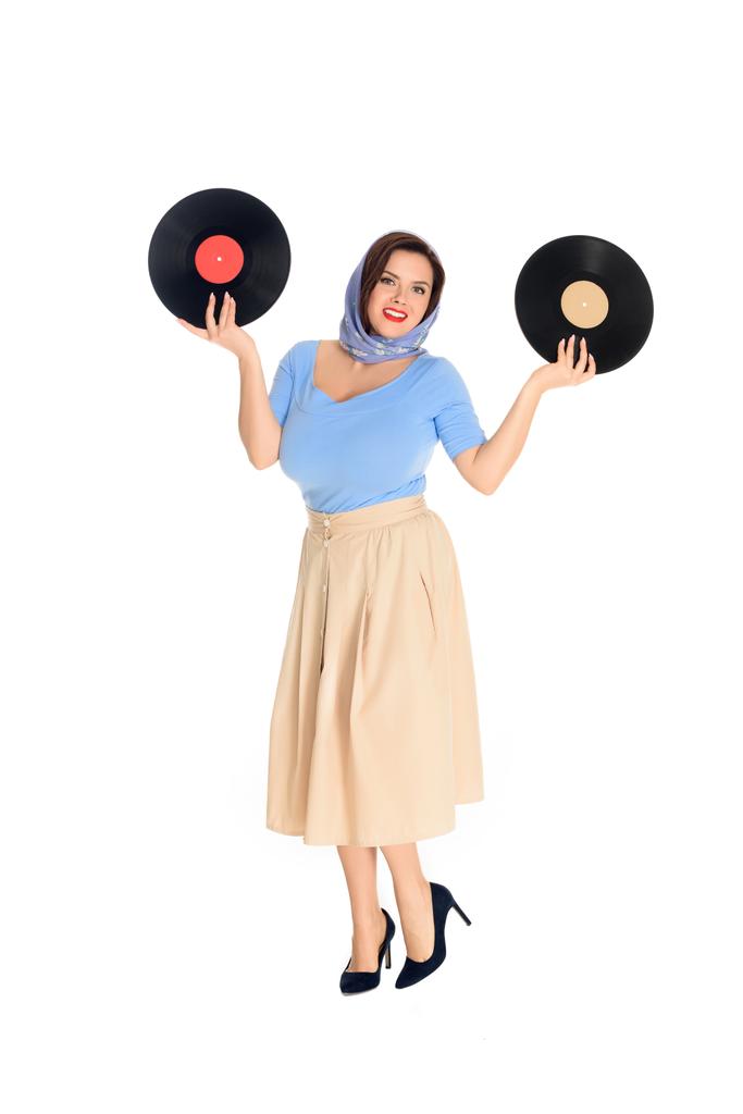 full length view of beautiful size plus pin up woman holding vinyl records and smiling at camera isolated on white  - Photo, Image