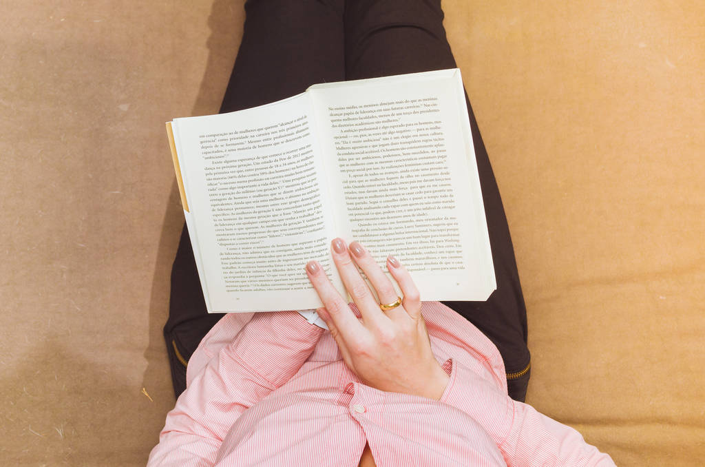 Nainen lukee kirjaa sohvalla, rentouttava. Koristeltu ilmapiiri
. - Valokuva, kuva