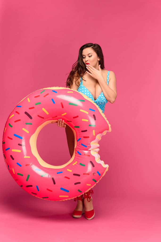 bela menina sexy em swimwear segurando donut inflável isolado em rosa
 - Foto, Imagem