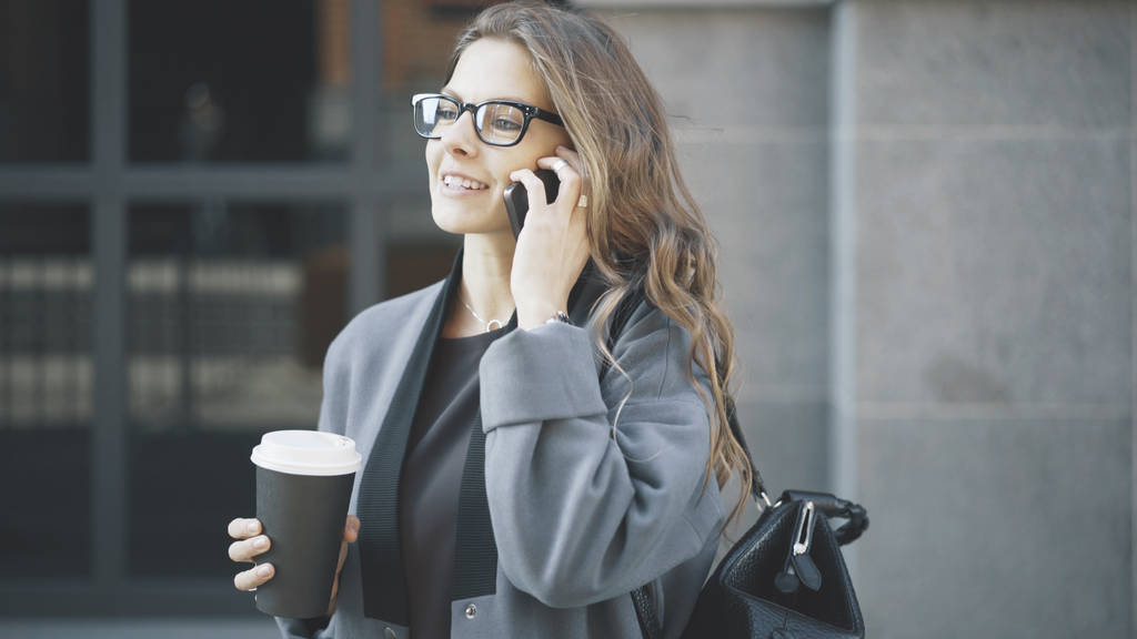 Mujer sonriente hablando por teléfono afuera
 - Foto, imagen