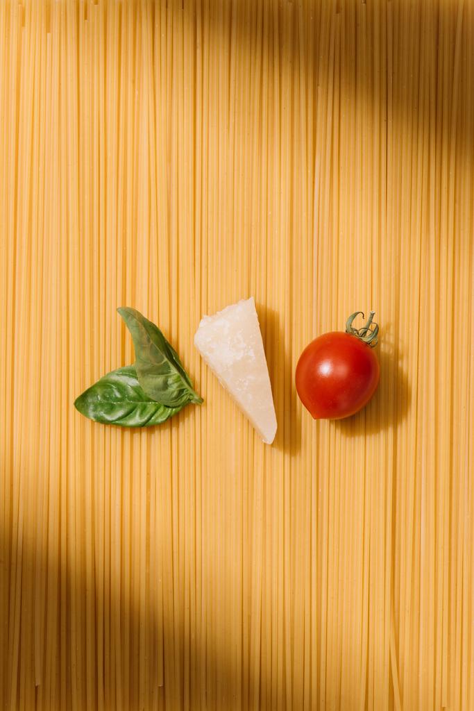 το Top view, Βασιλικός, τυρί και ντομάτα ξαπλωμένος στο σπαγγέτι - Φωτογραφία, εικόνα