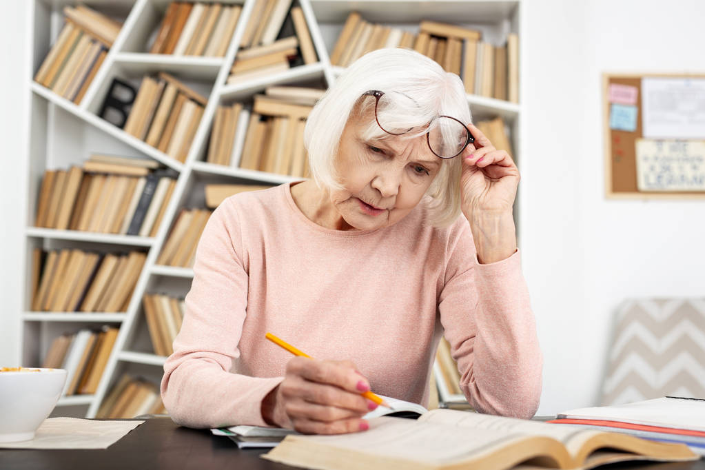Внимательная пожилая женщина, имеющая проблемы в учебе
 - Фото, изображение