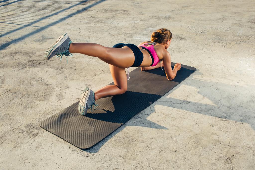 visão traseira de esportista fazendo exercício aeróbico no tapete de fitness
  - Foto, Imagem
