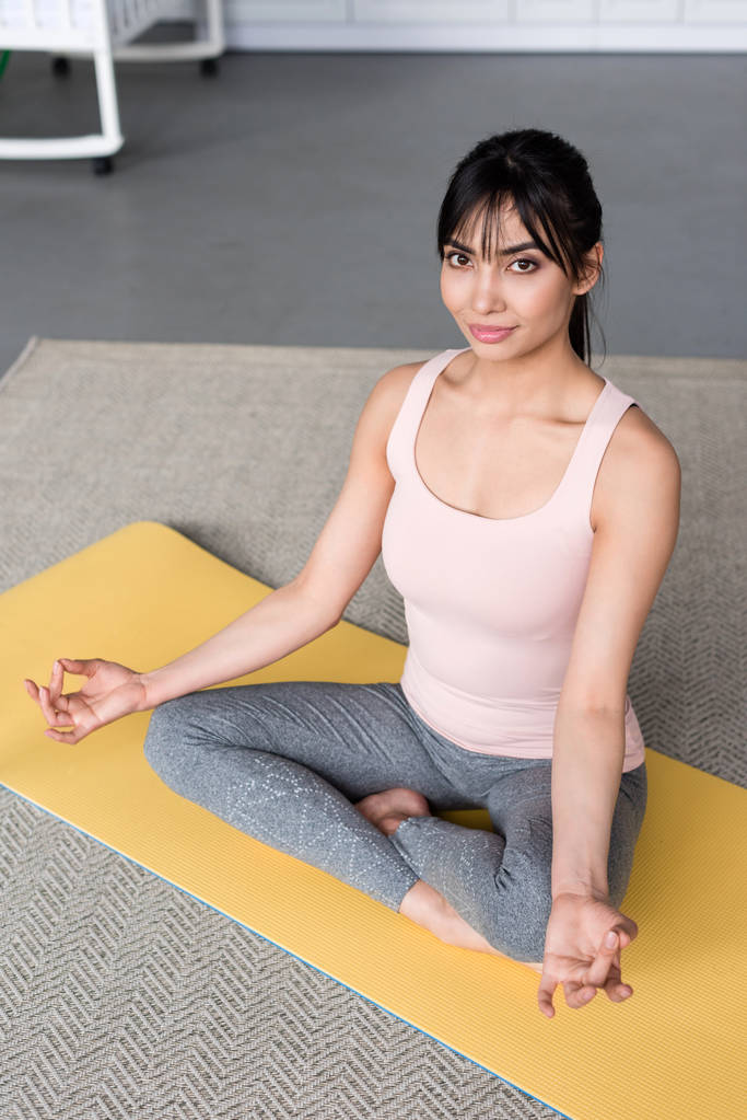 hermosa joven practicando yoga en pose de loto con gyan mudra en casa
 - Foto, imagen
