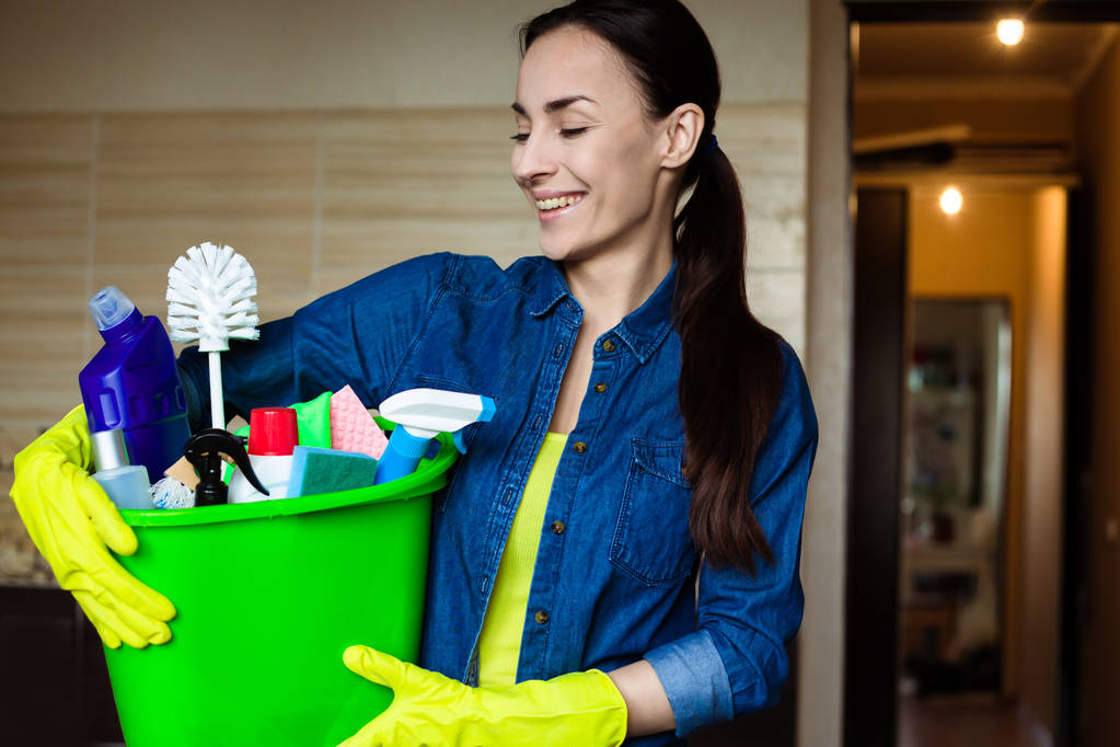 Жінка з обладнанням та приладдям для прибирання вдома в руках
 - Фото, зображення