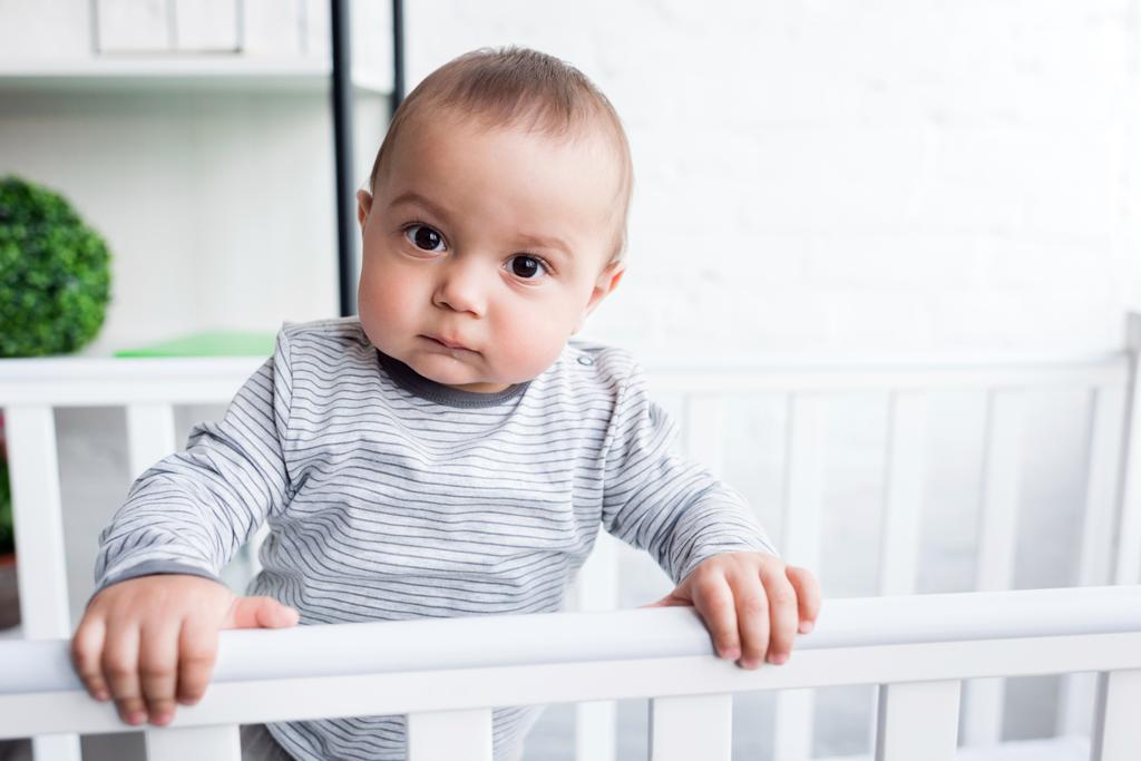 close-up portrait of adorable child in baby cot looking at camera - Photo, Image