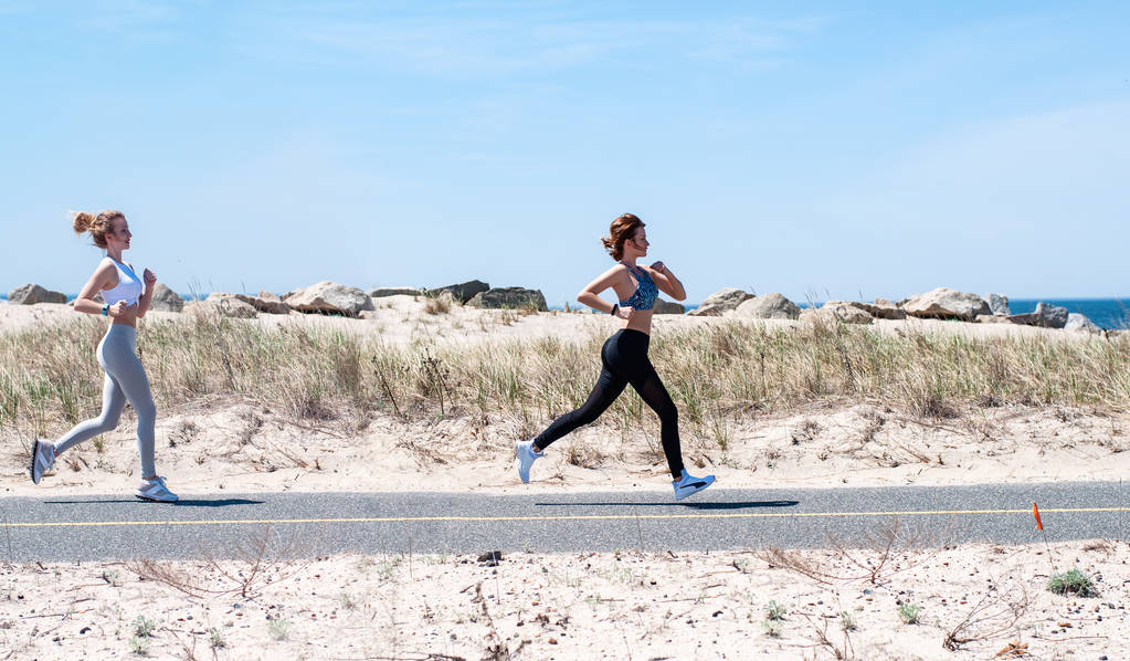 Fitness women running on beach. Happy girls woman jogging outdoors - Photo, Image