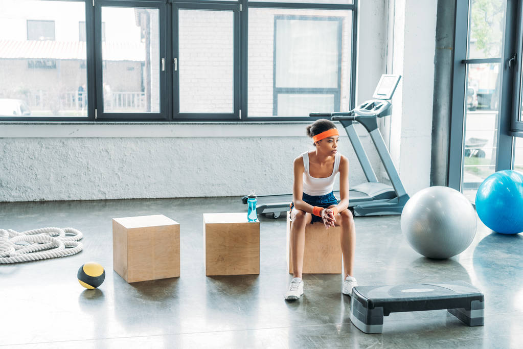 młodych kobiet sportowiec, siedząc na drewniane pudełko w siłowni  - Zdjęcie, obraz