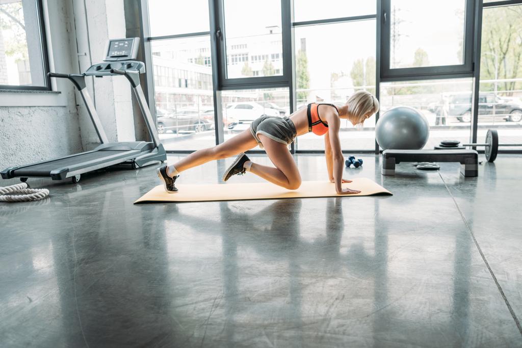vue latérale de la sportive faisant de l'exercice d'aérobic sur tapis de fitness à la salle de gym
 - Photo, image