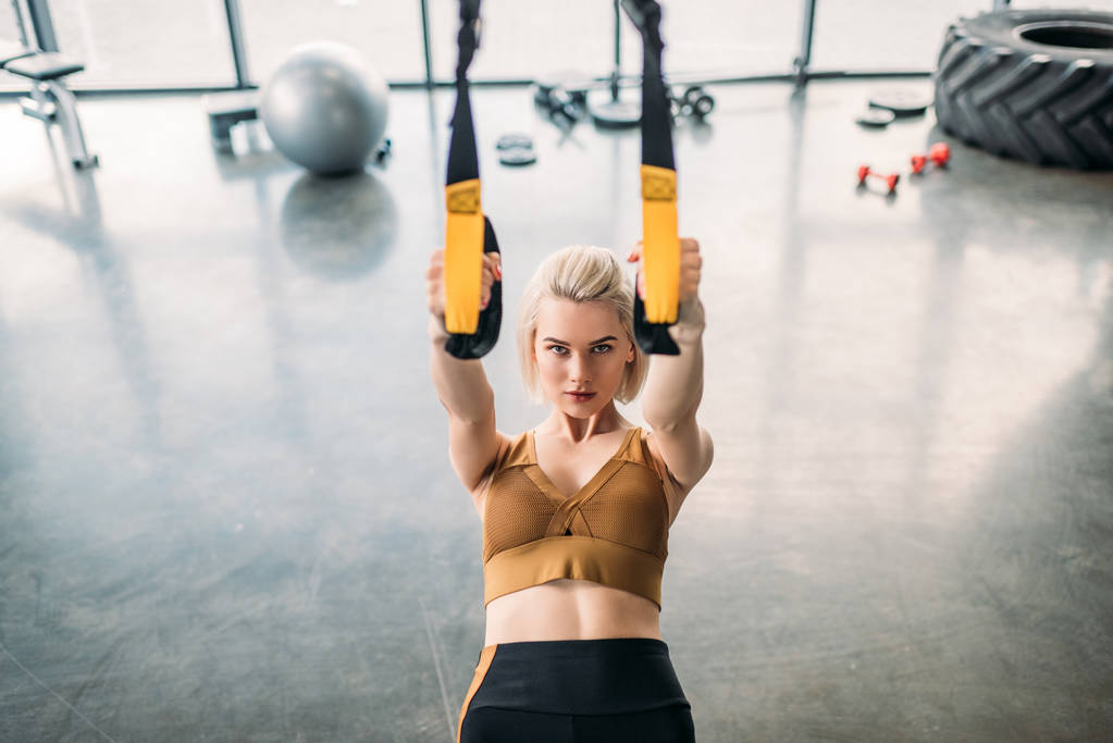 portrait of caucasian sportswoman training with resistance bands at gym - Photo, Image