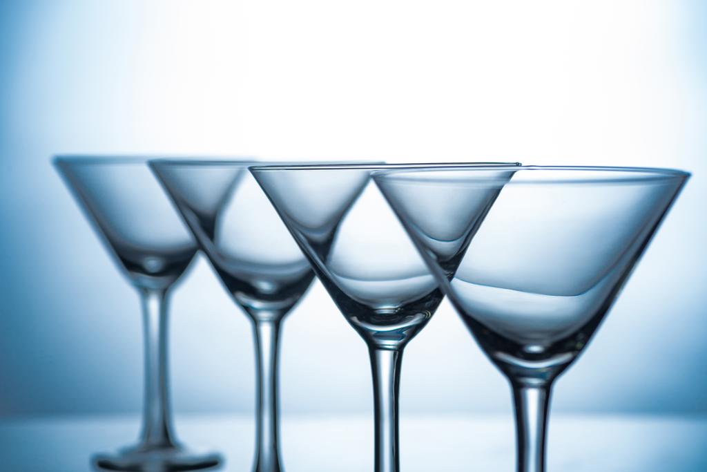 vida tranquila com linha de copos de martini vazios em cinza
 - Foto, Imagem
