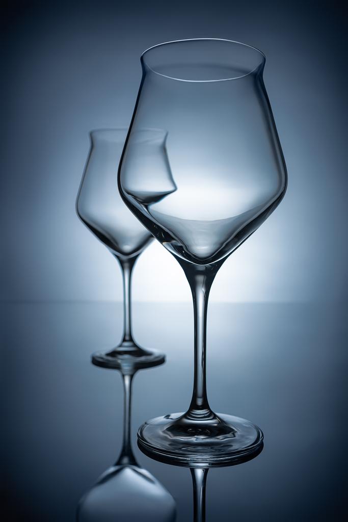 dos copas de vino transparentes vacías sobre gris con reflejos
 - Foto, imagen