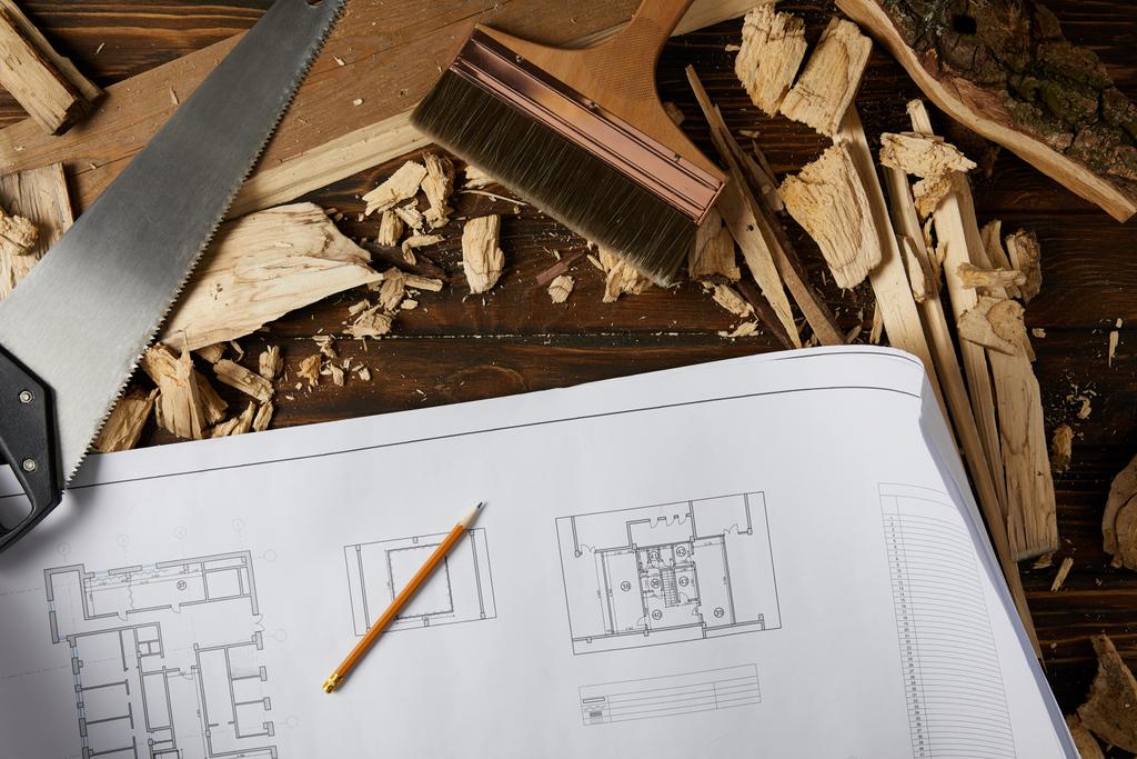 vista superior del plano, lápiz, pincel, sierra de mano y piezas de madera sobre la mesa
 - Foto, Imagen