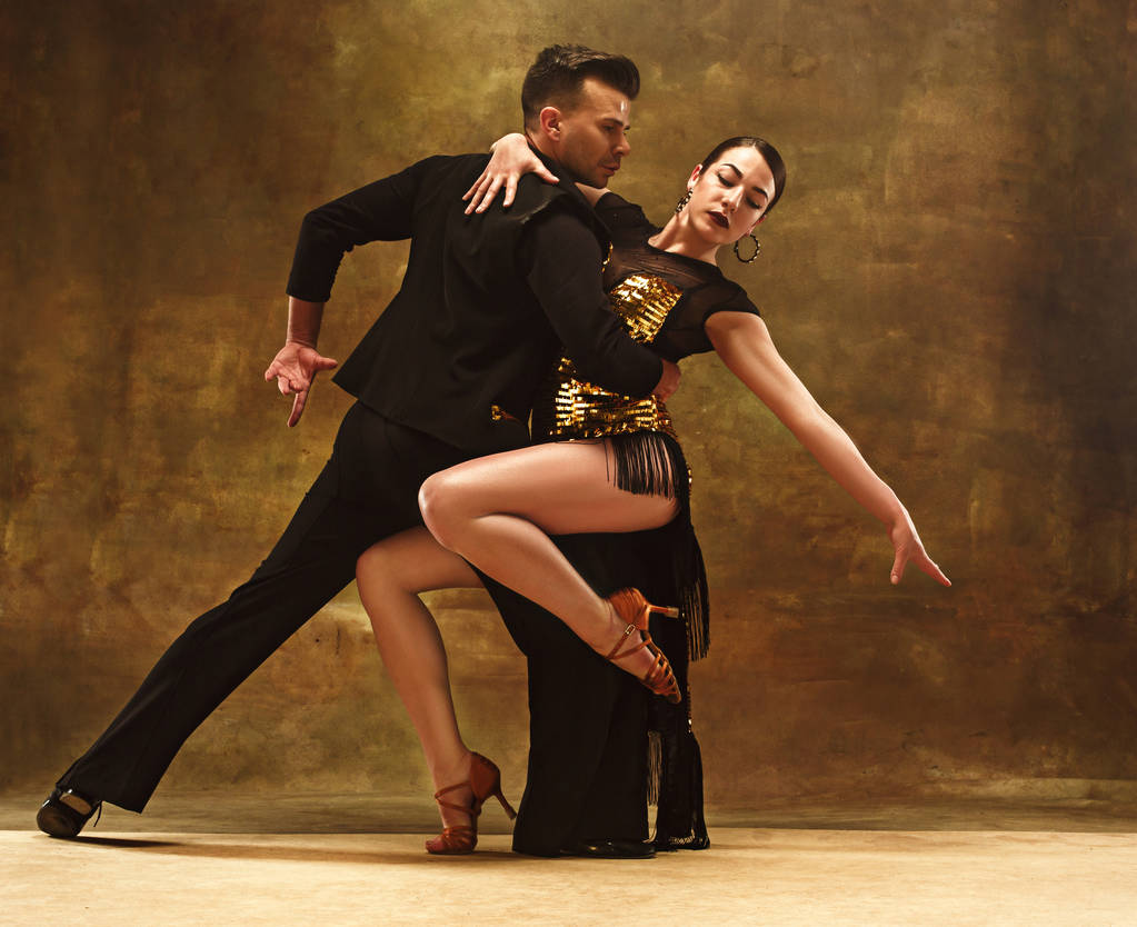 ballo sala da ballo coppia in abito d'oro danza su sfondo studio
. - Foto, immagini