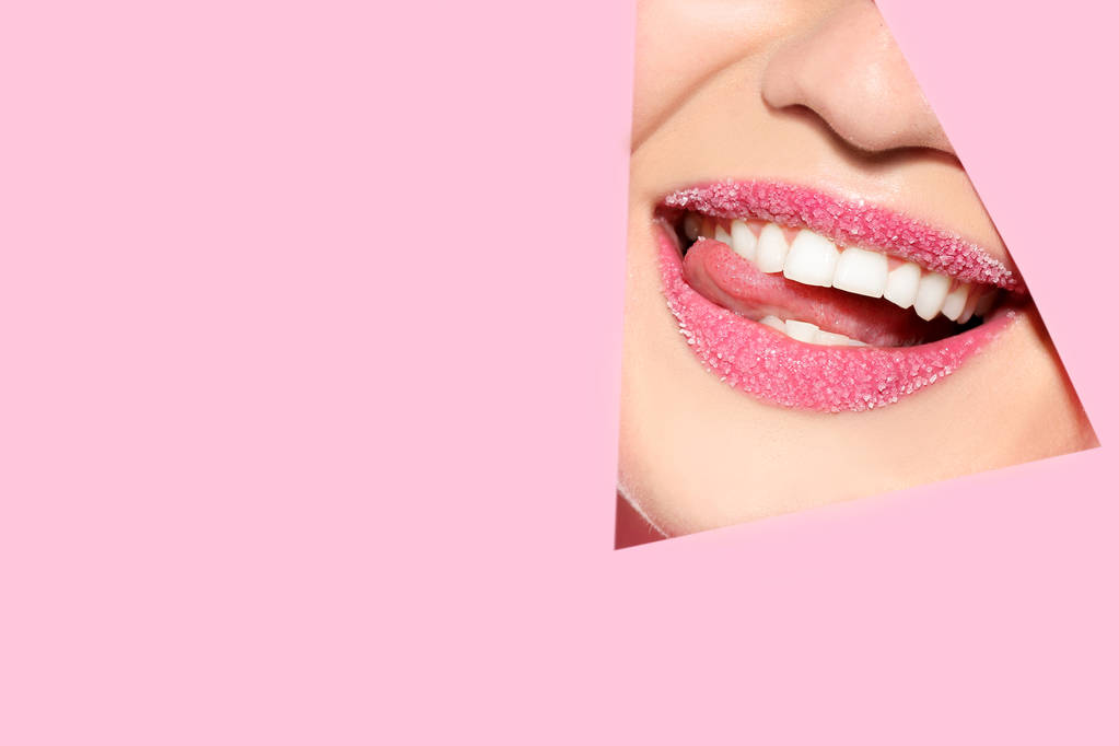 Vista de la hermosa mujer joven con labios de azúcar a través de recorte en papel de color
 - Foto, imagen