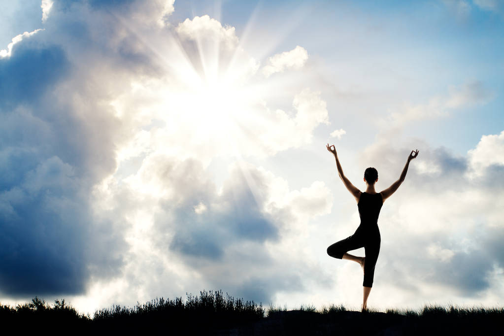 Jóga a meditáció, a nő áll a természetben, emberi meditál át nap háttérégbolt emelt karokkal - Fotó, kép