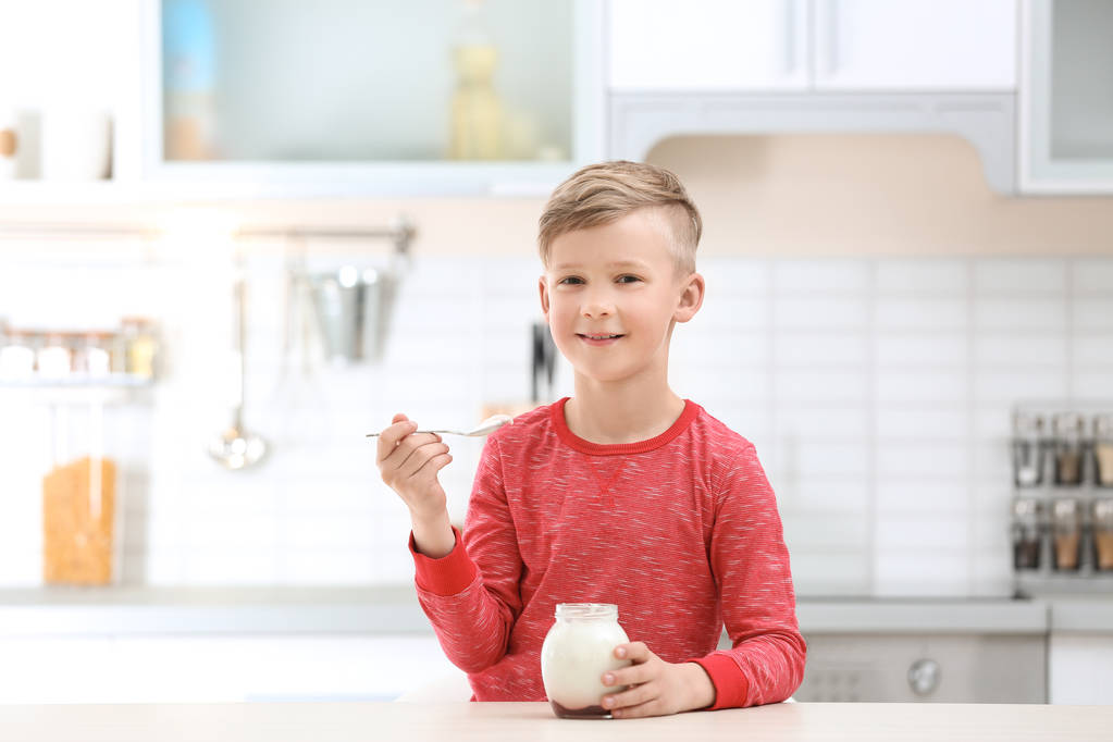 Kleiner Junge mit Joghurt in Küche - Foto, Bild
