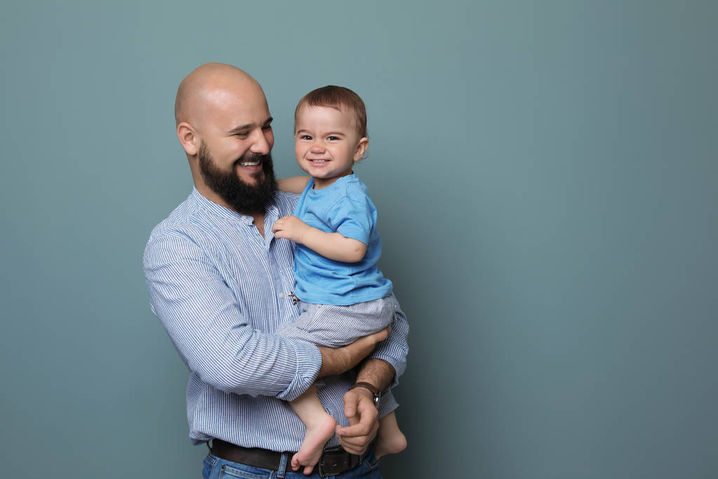Portret van vader en zijn zoontje op kleur achtergrond - Foto, afbeelding