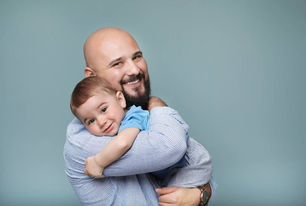 Portrait of dad and his little son on color background - Photo, Image