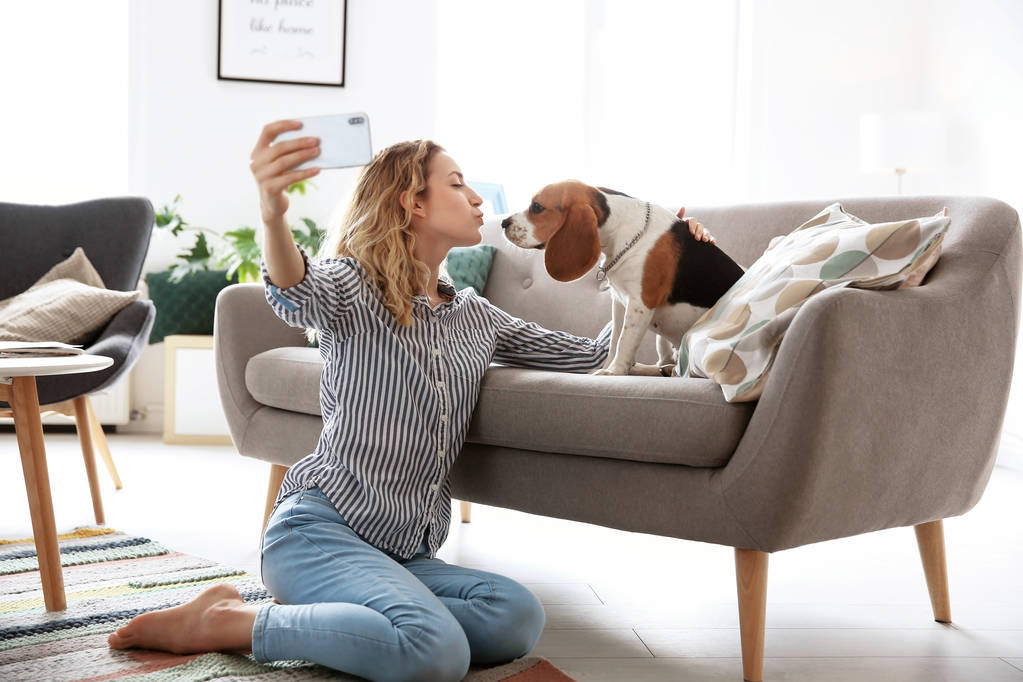 Young woman taking selfie with her dog at home - Photo, Image