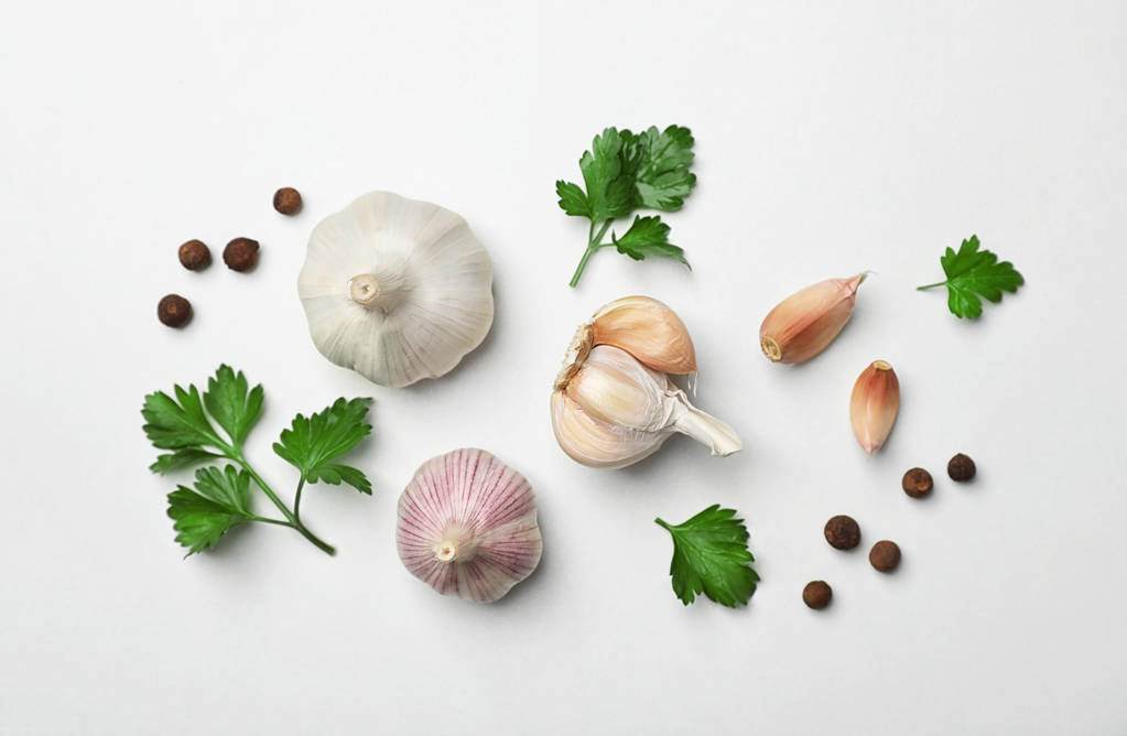 Flat lay composition with green parsley, pepper and garlic on light background - Photo, Image