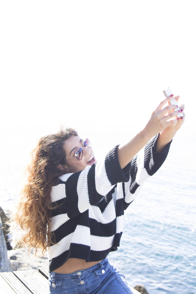 Junge Frau auf der Seebrücke wird zum Selfie - Foto, Bild