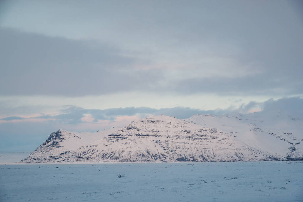 Paisaje icelandés dramático con montañas nevadas. Día frío de invierno en Islandia
. - Foto, imagen