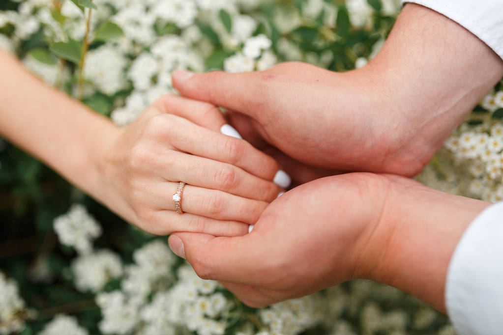 Az ember, így egy eljegyzési gyűrűt a barátnőjét a virágoskert, kezét. Barátja meglepte barátnője, eljegyzési gyűrű, virágoskert. - Fotó, kép