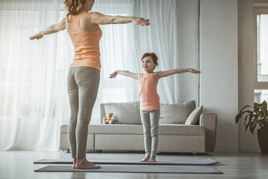 Boldog lány és anya csinál egyszerű sport gyakorlatok  - Fotó, kép