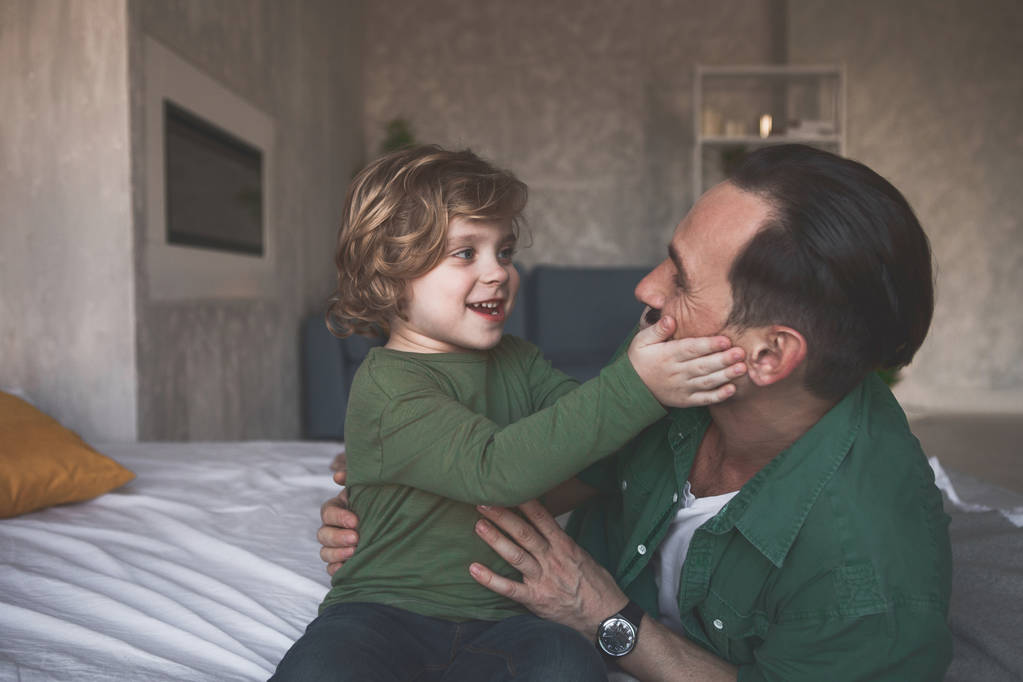 Cheerful kid playing with glad dad - Photo, Image
