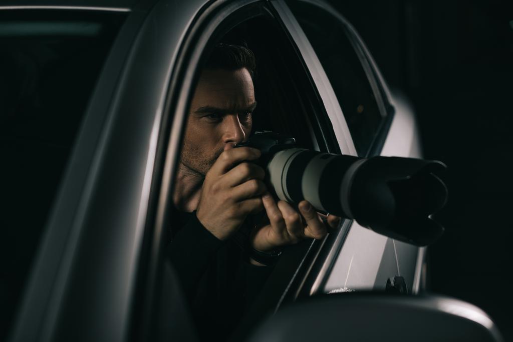 Tarkennettu paparazzi tekee valvontaa kameralla autostaan
  - Valokuva, kuva