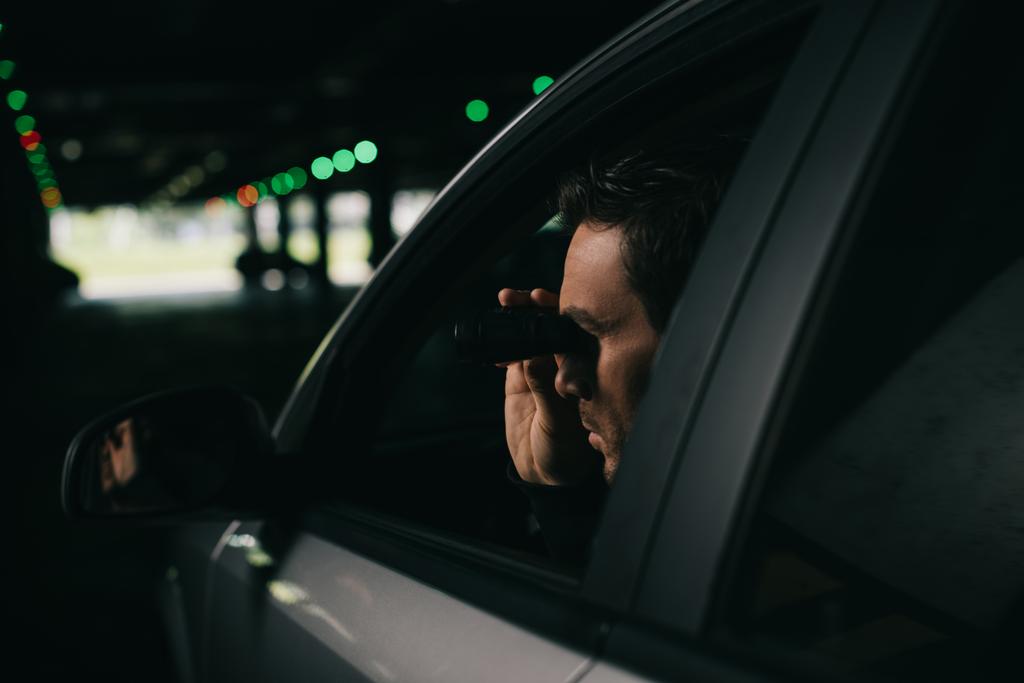 αρσενικό παπαράτσι κάνει επιτήρηση με κιάλια από αυτοκίνητο  - Φωτογραφία, εικόνα