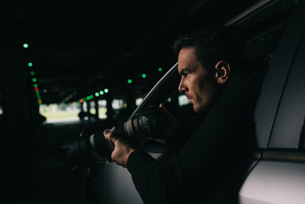 sivukuva miespuolisista paparazzeista tekemässä valvontaa kameralla autostaan
  - Valokuva, kuva