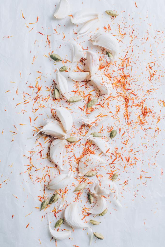 pohled z rozptýlených česneku a koření na bílém stole - Fotografie, Obrázek