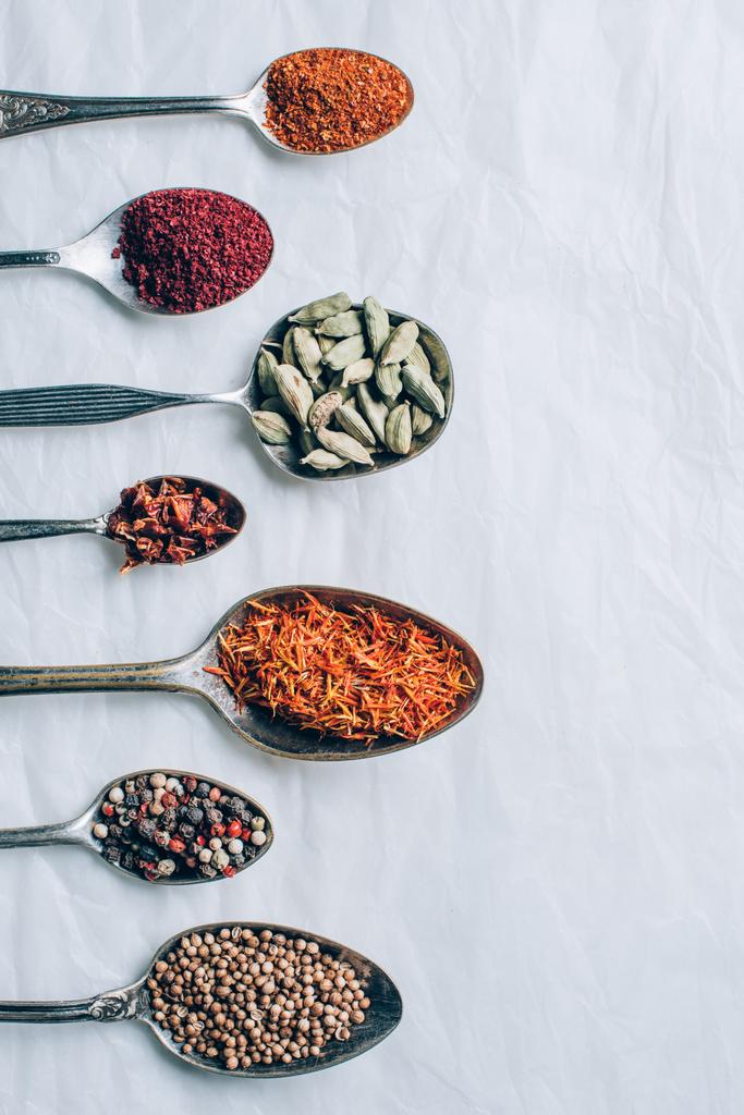 top view of colorful spices in spoons on white table - Photo, Image