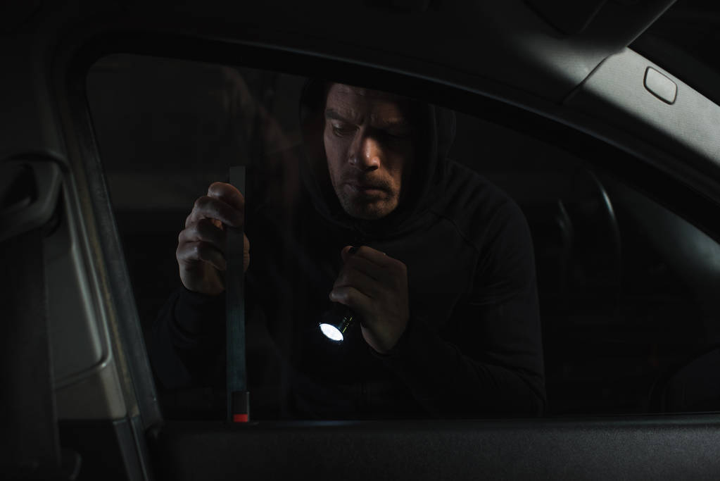 懐中電灯をバール車を侵入と男性泥棒  - 写真・画像