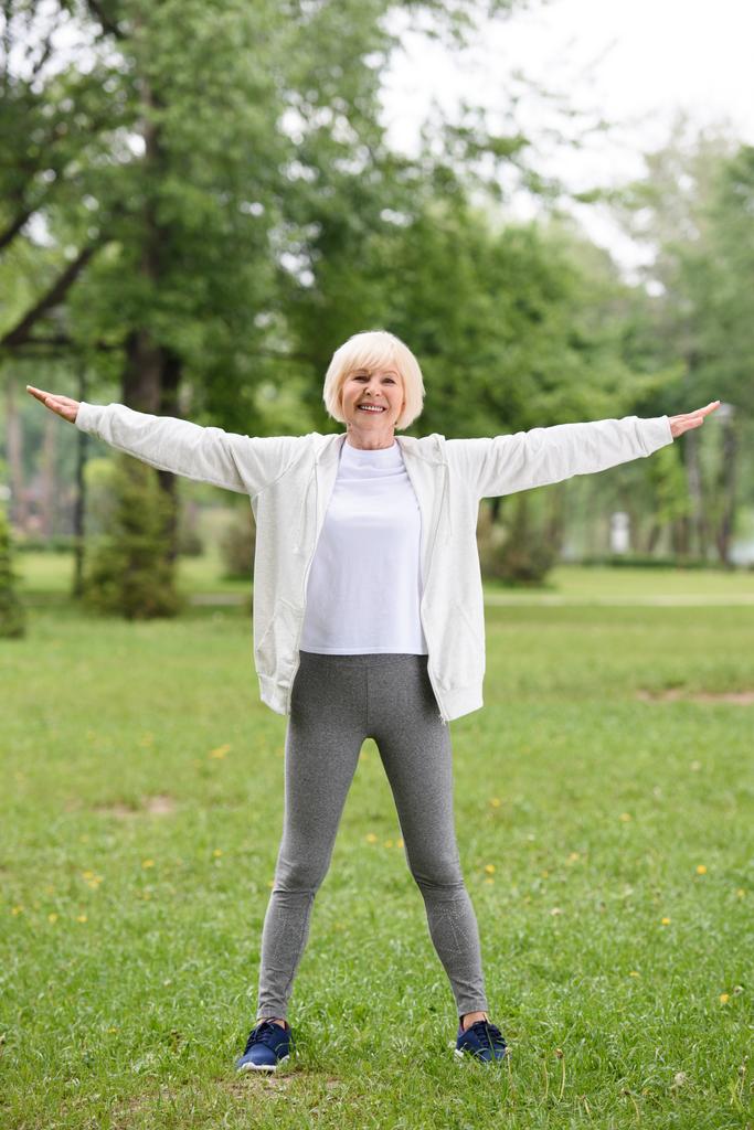 usměvavá vedoucí sportovkyně školení na zeleném trávníku v parku - Fotografie, Obrázek