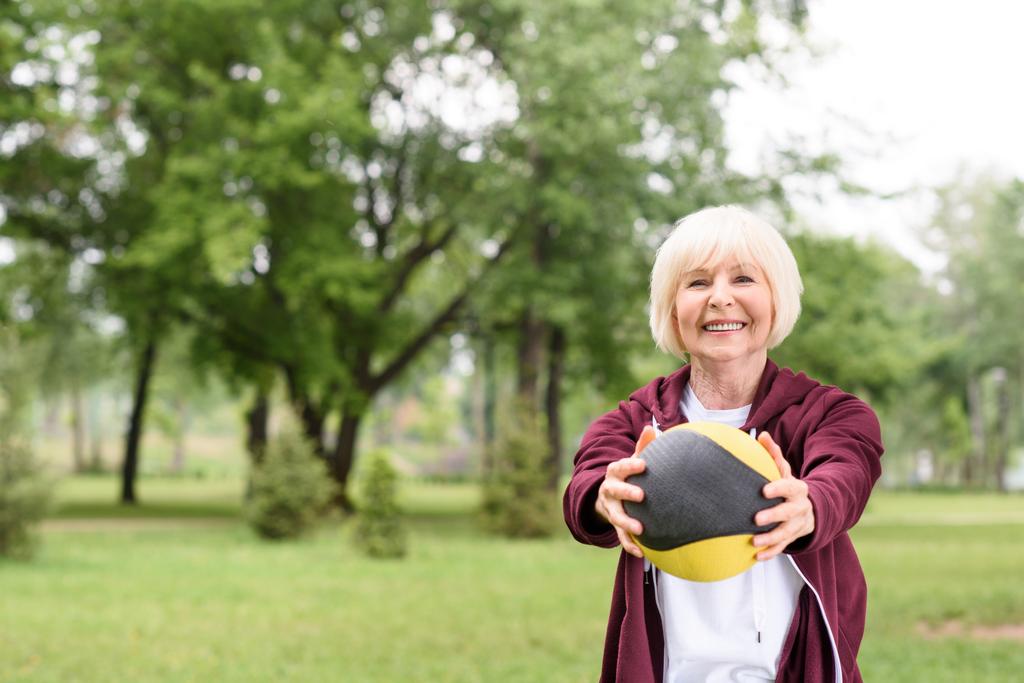 deportista senior entrenando con balón de medicina en el parque
 - Foto, Imagen