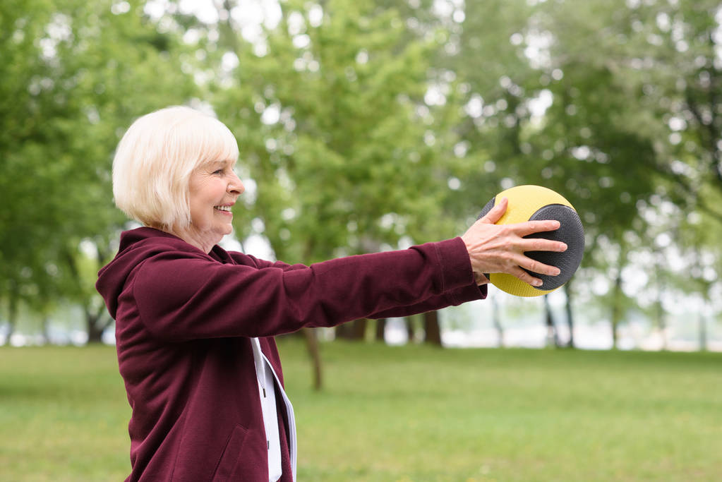 高齢者の女性が公園で薬のボール運動 - 写真・画像