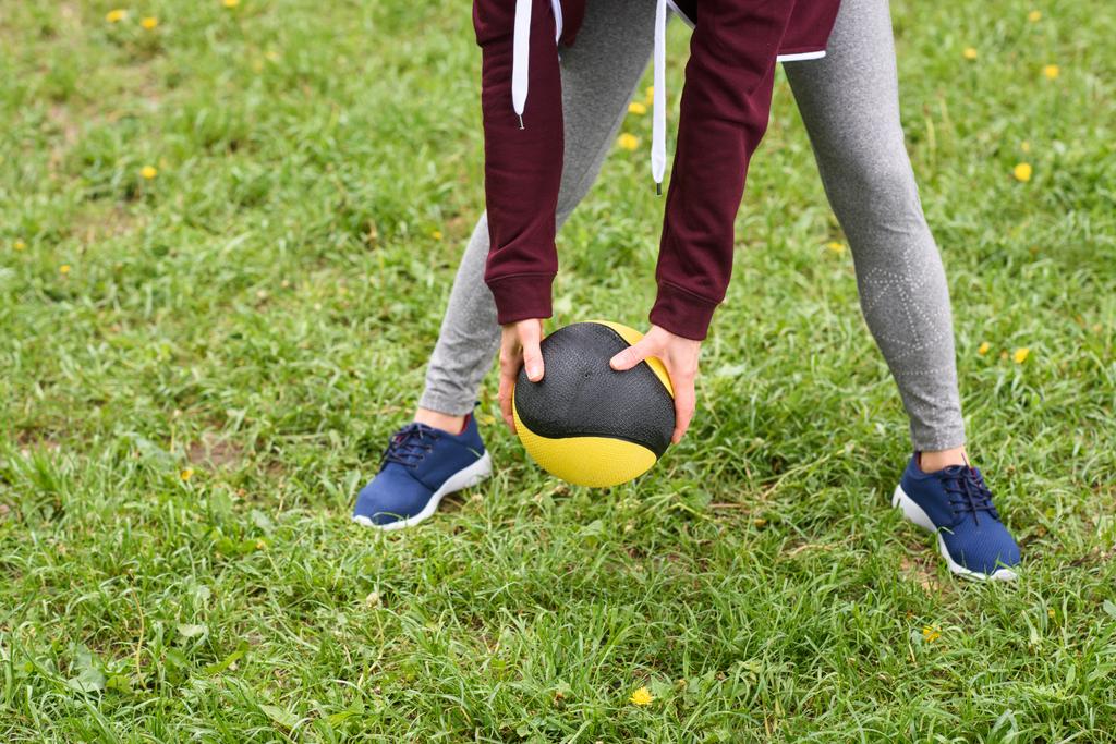 Ausgeschnittene Ansicht von Frauen beim Training mit Medizinball auf grünem Gras - Foto, Bild